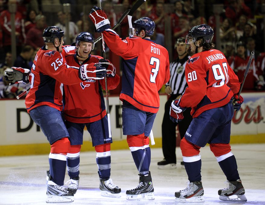 Washington Capitals defenseman Steven Oleksy, second from left, celebrate his goal with teammates Jason Chimera (25), Tom Poti (3) and Marcus Johansson (90), of Sweden, during the first period of an NHL hockey game, Sunday, March 10, 2013, in Washington. (AP Photo/Nick Wass)