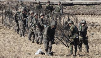 South Korean Army soldiers set up barbed wire fence during an exercise against possible attacks by North Korea near the border village of Panmunjom in Paju, South Korea, Monday, March 11, 2013. (AP Photo/Ahn Young-joon)

