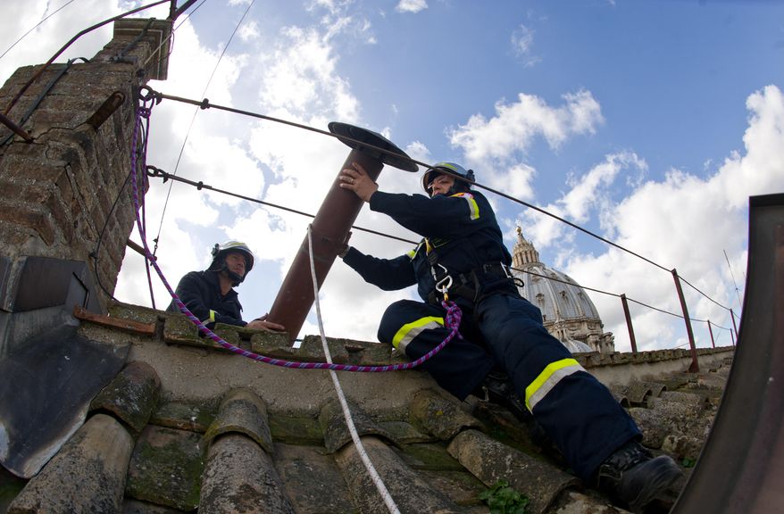Firefighters install the top of the Sistine Chapel chimney at the Vatican on Saturday, March 9, 2013. Smoke from the chimney during the conclave of cardinals will signal whether or not a new pope has been elected. (AP Photo/L'Osservatore Romano)