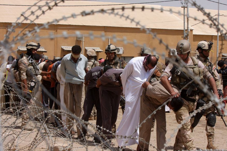 ** FILE ** In this Friday, July 20, 2012, file photo, blindfolded and handcuffed suspected al Qaeda members are led away to detention centers in an Iraqi army base in Hillah, Iraq. (AP Photo/ Alaa al-Marjani, File)