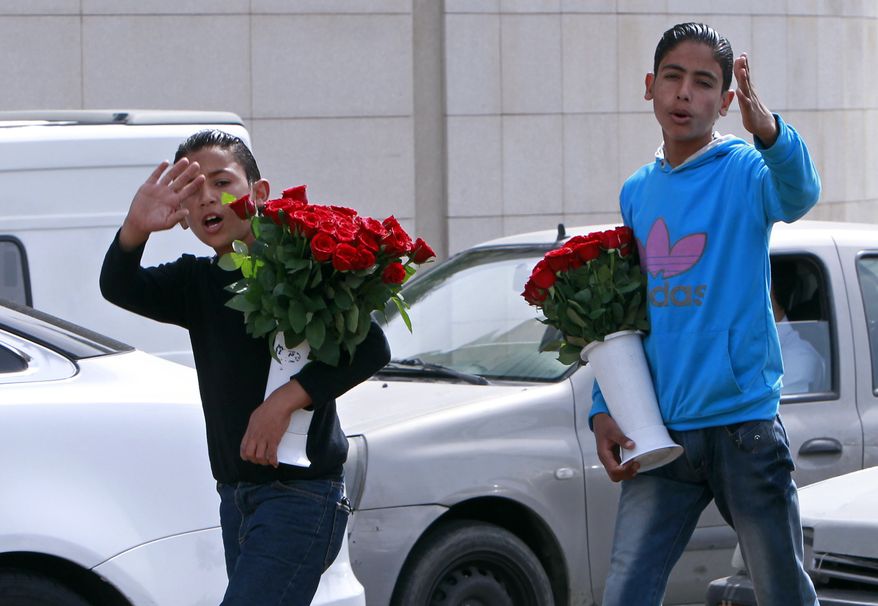 Two Syrian brothers Bashar, 12, left, and Rasem, 14, right, who fled their home from Hassakeh, try to sell flowers to make a living in Beirut, Lebanon, Wednesday, March 13, 2013. Save the Children, which is providing humanitarian and relief in Syria and neighboring countries, called on all groups taking part in the conflict to allow unfettered, safe access to populations in need and to "ensure that everything is done to bring the fighting to an end." (AP Photo/Bilal Hussein)