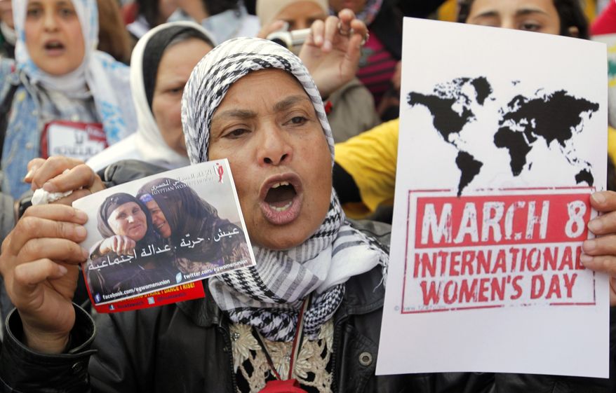 An Egyptian woman shouts anti-Muslim Brotherhood slogans during a demonstration in Cairo on Friday, March 8, 2013, marking International Women's Day. The Arabic reads, "Bread, freedom, social justice." (AP Photo/Amr Nabil)