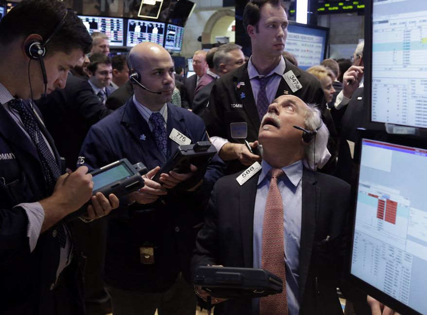 Peter Tuchman (right) works with fellow traders on the floor of the New York Stock Exchange on March 15, 2013. (Associated Press)