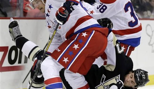 Pittsburgh Penguins right wing Craig Adams (27) collides with Washington Capitals center Jay Beagle (83) in the second period of an NHL hockey game in Pittsburgh Tuesday, March 19, 2013. (AP Photo/Gene J. Puskar)