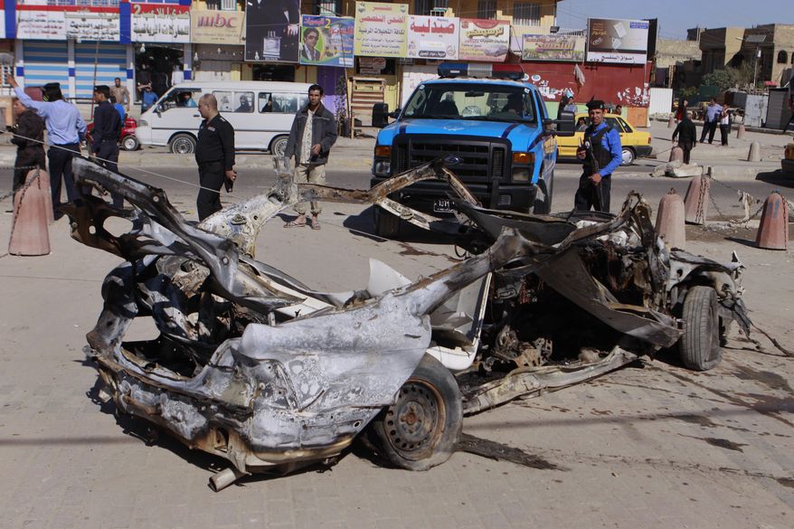 Iraqi security forces inspect the scene of a car bomb attack in the Shiite stronghold of Sadr City, Baghdad, Iraq, Tuesday, March 19, 2013. Insurgents unleashed deadly attacks Tuesday against Shiite areas of Baghdad, killing and wounding scores of people, police said. (AP Photo/Karim Kadim)