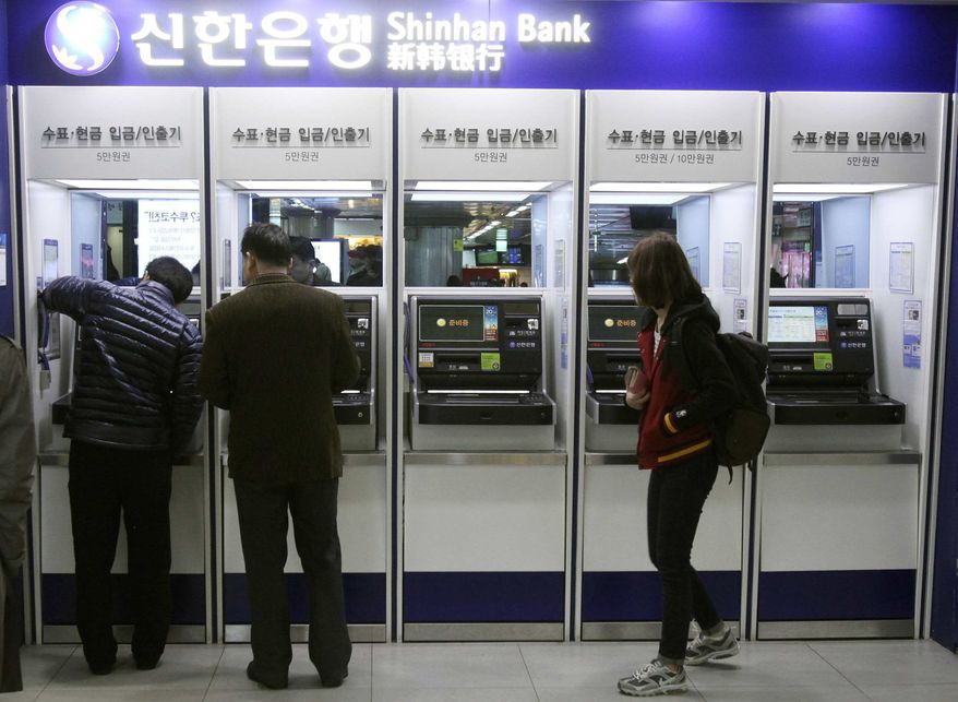 Depositors try to use automated teller machines of Shinhan Bank while the bank's computer networks are paralyzed at a subway station in Seoul, South Korea, Wednesday, March 20, 2013. (AP Photo/Ahn Young-joon)