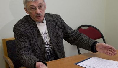 Oleg Orlov, a member of the Russian human rights group Memorial, talks to the media in his office in Moscow on Thursday, March 21, 2013, as prosecutors search for documents pertaining to all of the organization&#39;s activities. (AP Photo/Ivan Sekretarev)