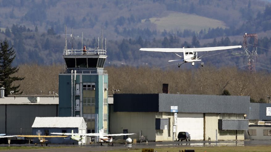 A small plane takes off past the control tower at Troutdale Airport in Troutdale, Ore., on March 7, 2013. (Associated Press)