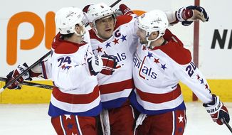 Washington Capitals&#39; Alex Ovechkin (8), John Carlson (74) and Troy Brouwer (20) celebrate Ovechkin&#39;s goal against the Winnipeg Jets during the third period of an NHL hockey game in Winnipeg, Manitoba, on Thursday, March 21, 2013. The Capitals won 4-0. (AP Photo/The Canadian Press, John Woods)