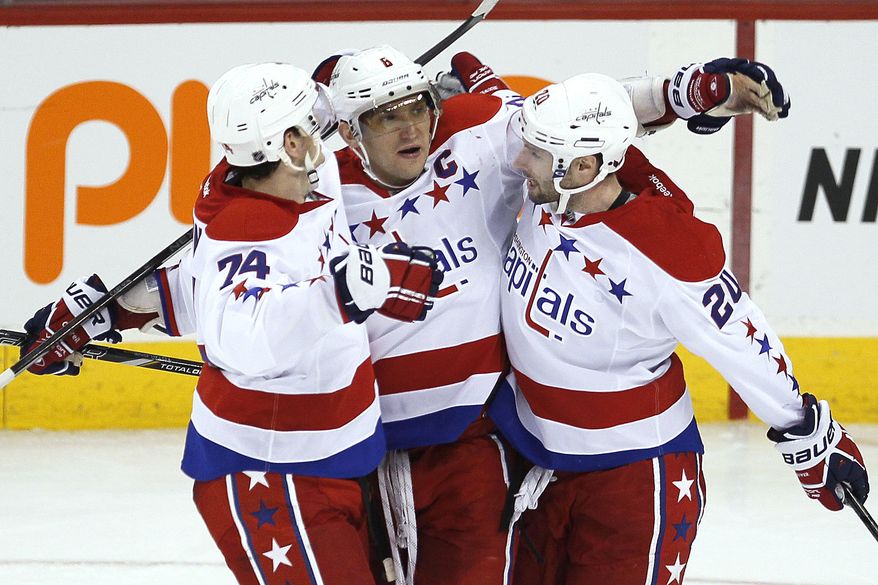 Washington Capitals' Alex Ovechkin (8), John Carlson (74) and Troy Brouwer (20) celebrate Ovechkin's goal against the Winnipeg Jets during the third period of an NHL hockey game in Winnipeg, Manitoba, on Thursday, March 21, 2013. The Capitals won 4-0. (AP Photo/The Canadian Press, John Woods)