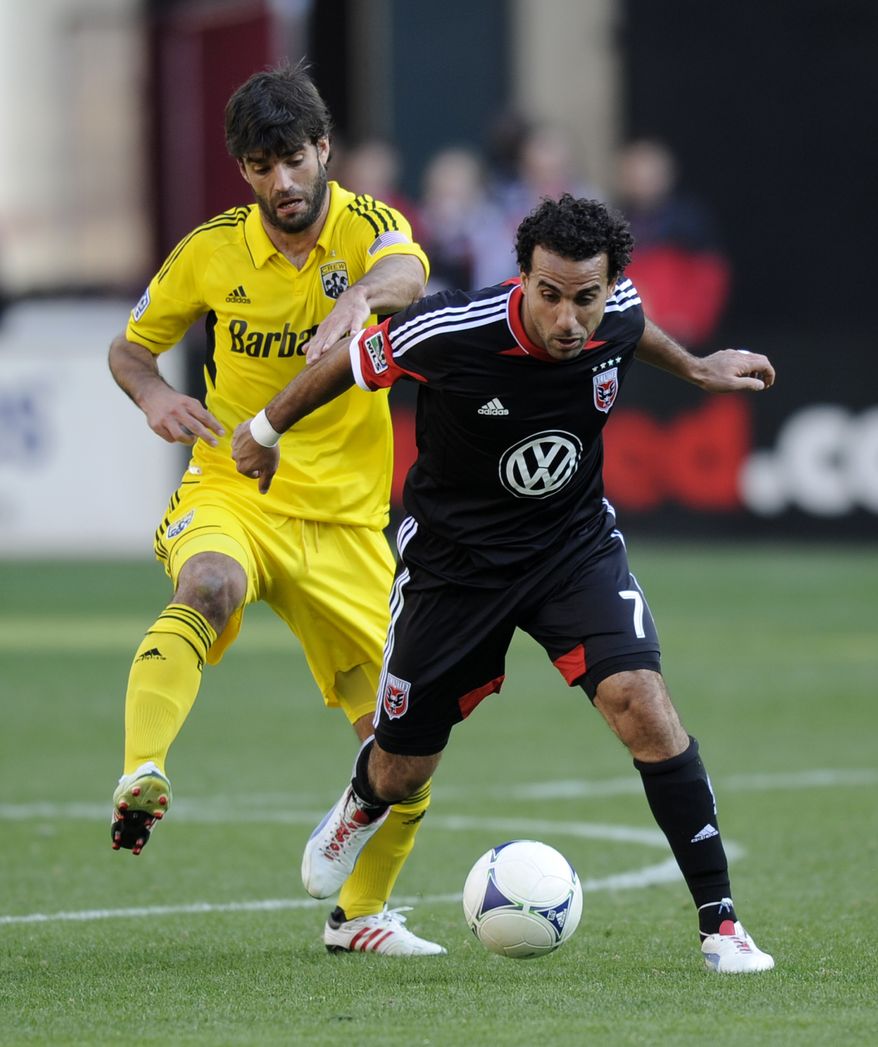 Columbus Crew defender/midfielder Agustin Viana, left, fights for the ball against D.C. United midfielder Dwayne De Rosario (7) during the second half of an MLS soccer game on Saturday, March 23, 2013, in Washington. Columbus won 2-1. (AP Photo/Nick Wass)