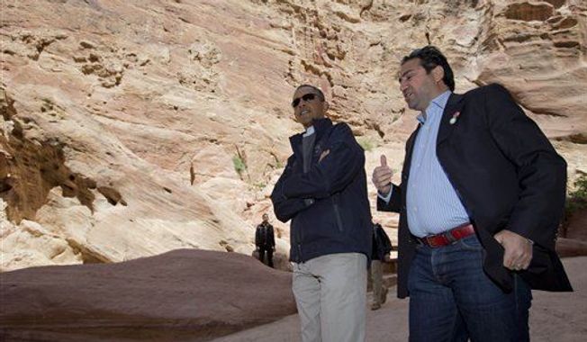 U.S. President Barack Obama, left, with Dr. Suleiman A.D. Al Farajat, a tourism professor with the University of Jordan, walks from the Ancient Shrine, at right, in the Siq during a visit to the ancient city of Petra, in south Jordan, Saturday, March 23, 2013. (AP Photo/Carolyn Kaster)