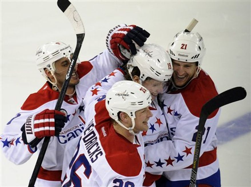 Washington Capitals' Nicklas Backstrom (19), left, of Sweden, celebrates with teammates Brooks Laich (21), Matt Hendricks (26), and Mike Ribeiro (9) after Backstrom scored during the shootout to defeat the New York Rangers, 3-2, in an NHL hockey game Sunday, March 24, 2013, at Madison Square Garden in New York. (AP Photo/Bill Kostroun)