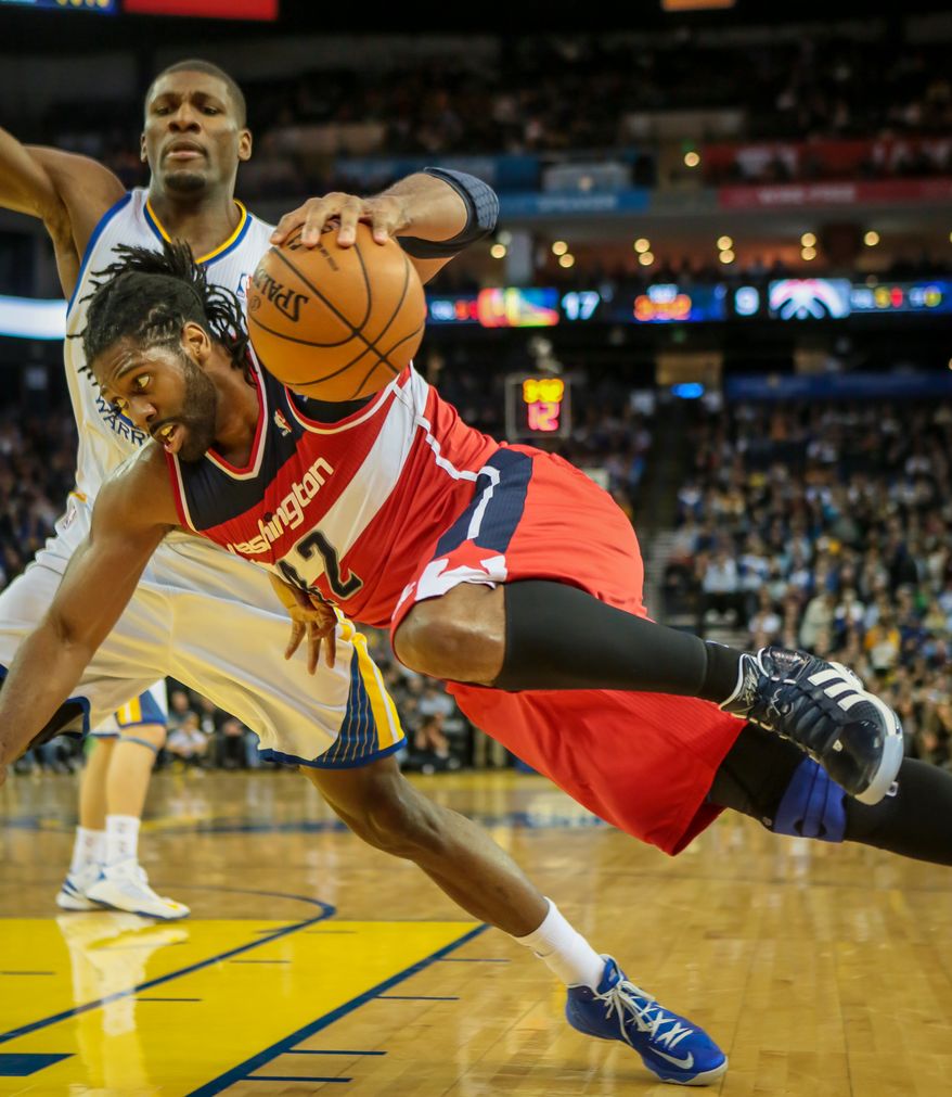 Washington Wizards' Nene drives to the basket against Golden State Warriors' Festus Ezeli in the first quarter of an NBA basketball game in Oakland, Calif., Saturday, March 23, 2013. (AP Photo/John Storey)