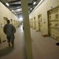 ** FILE ** This Sept. 27, 2010, file photo reviewed by the U.S. military, shows a U.S. military guard walking a corridor between detainee cells at the Parwan detention facility near Bagram, north of Kabul, Afghanistan. (AP Photo/David Guttenfelder, File)