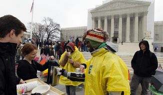 Jeff Thomson (left) and Kelsi Browning hands out free coffee to people who wait outside of the U.S. Supreme Court in Washington on March, 25, 2013, a day before the case for gay and lesbian couples rights, will be argued before the Supreme Court. (Associated Press)