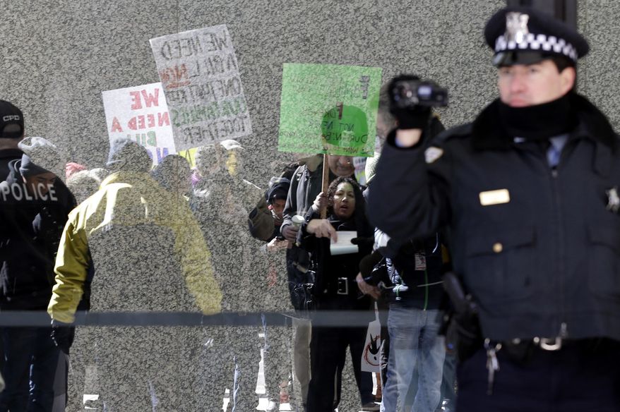 ** FILE ** Protesters hold signs for immigrant rights outside of Kluczynski Federal Building in downtown Chicago, Friday, March 22, 2013. (AP Photo/Nam Y. Huh)