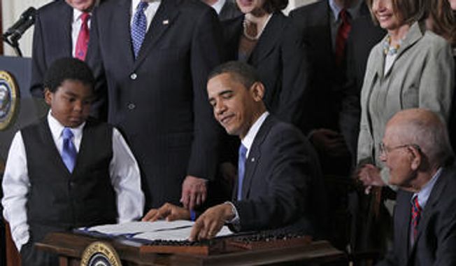 ** FILE ** President Obama signs the Affordable Care Act in 2010 at the White House. 