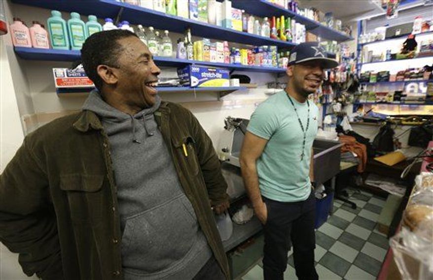 Casiano Quezada, right, talks to an unidentified friend inside Apple Deli Grocery, Tuesday, March 26, 2013, in Passaic, N.J. Quezada is the son of Pedro Quezada, 44, who won the $338 million Powerball jackpot after purchasing the winning ticket at Eagle Liquors store in Passaic. (AP Photo/Julio Cortez)