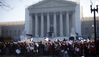 Demonstrators stand outside the Supreme Court in Washington, Tuesday, March 26, 2013, where the court will hear arguments on California’s voter approved ban on same-sex marriage, Proposition 8. (AP Photo/Pablo Martinez Monsivais)