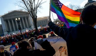 Franco Ciammachilli (right) of Washington waves a rainbow flag, a symbol of gay pride, behind supporters of traditional marriage outside the U.S. Supreme Court in Washington as the justices began hearing two days of arguments in cases involving gay marriage on March 26, 2013. (Andrew Harnik/The Washington Times) **FILE** 
