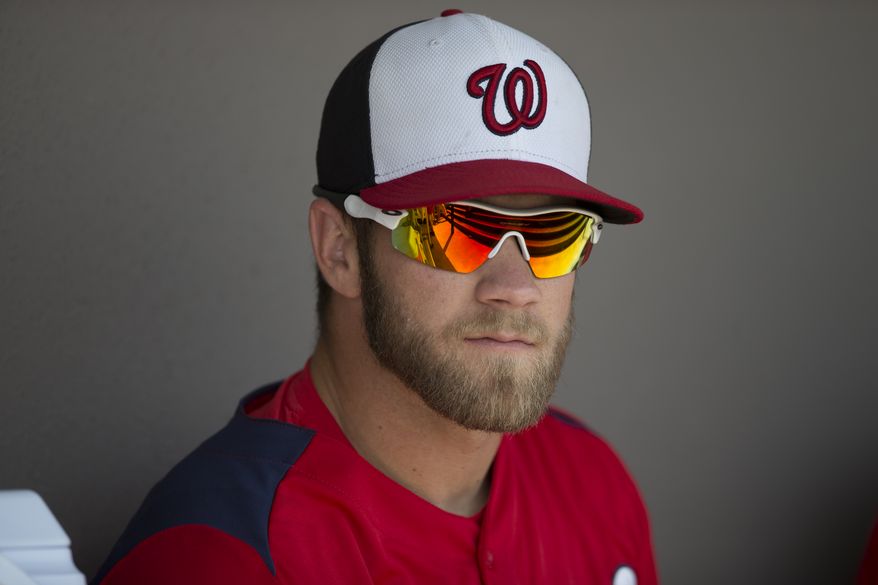 Washington Nationals outfielder Bryce Harper sits in the dugout before the start of an exhibition spring training baseball game against the Atlanta Braves on Sunday, March 24, 2013, in Viera, Fla. (AP Photo/Evan Vucci)