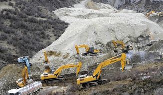 In this photo released by China&#x27;s Xinhua News Agency, earthmovers remove rocks and mud on the scene where a landslide hit a mining area in Maizhokunggar County of Lhasa, southwest China&#x27;s Tibet Autonomous Region, on March 29, 2013. The large landslide trapped dozens of workers in the gold mining area, state media reported. (Associated Press/Xinhua)