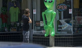 ** FILE ** A tourist photographs an alien outside a T-shirt and souvenir shop in Roswell, N.M., in 2007. (Associated Press)
