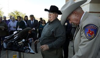 **FILE** David Byrnes (right), Sheriff of Kaufman County, bows his head as Mike McLelland, District Attorney of Kaufman County answers questions at a Jan. 31, 2013, news conference at the Kaufman Law Enforcement Center in Kaufman, Texas. (Associated Press/The Dallas Morning News)