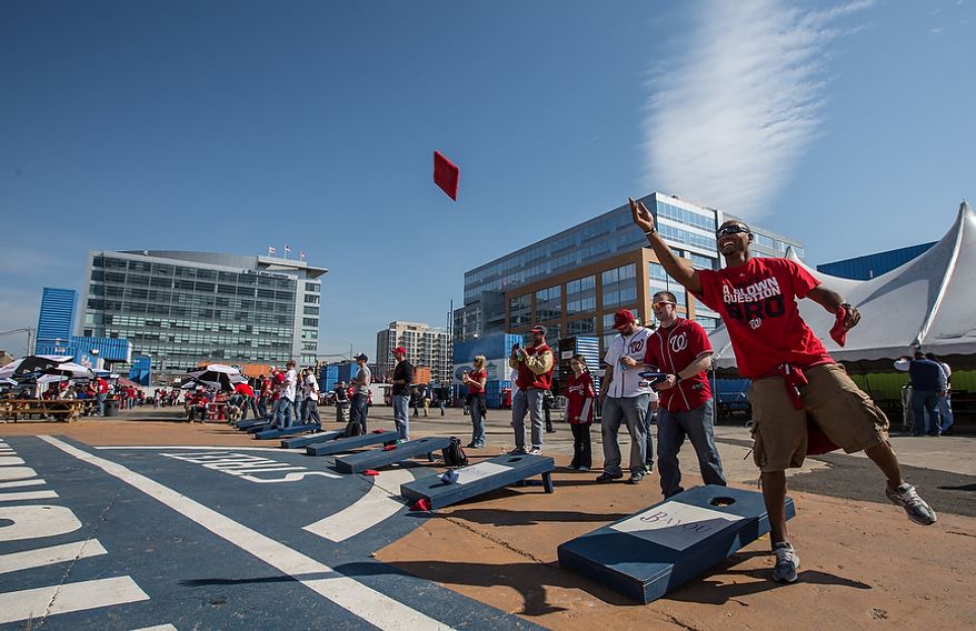 Warren Gorman tosses a bean bag during a game of corn hole before watching the Washington Nationals play the the Miami Marlins on opening day, in Washington, DC., Monday, April 1, 2013. (Andrew S Geraci/The Washington Times)