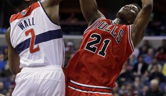 Chicago Bulls forward Jimmy Butler (21) shoots in front of Washington Wizards guard John Wall (2) in the first half of an NBA basketball game Tuesday, April 2, 2013, in Washington. (AP Photo/Alex Brandon)