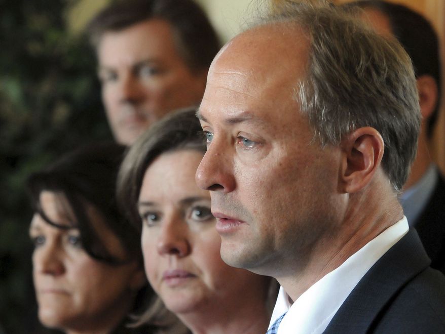 Mark Barden, right, father of Sandy Hook Elementary School shooting victim Daniel Barden, speaks alongside his wife, Jackie, center, and other Newtown parents, at the Capital in Hartford, Conn., Monday, April 1, 2013. Families of the school shooting victims were there to ask lawmakers to include a ban on existing high-capacity magazines in a legislation addressing gun control spurred by the massacre. (AP Photo/New Haven Register, Mara Lavitt)