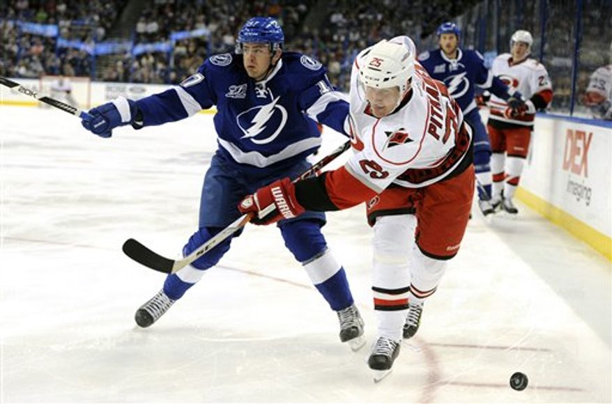 Carolina Hurricanes defenseman Joni Pitkanen, of Finland, and Tampa Bay Lightning center Alex Killorn, left, go for the puck during the first period of an NHL hockey game Saturday, March 16, 2013, in Tampa, Fla. (AP Photo/Brian Blanco)
