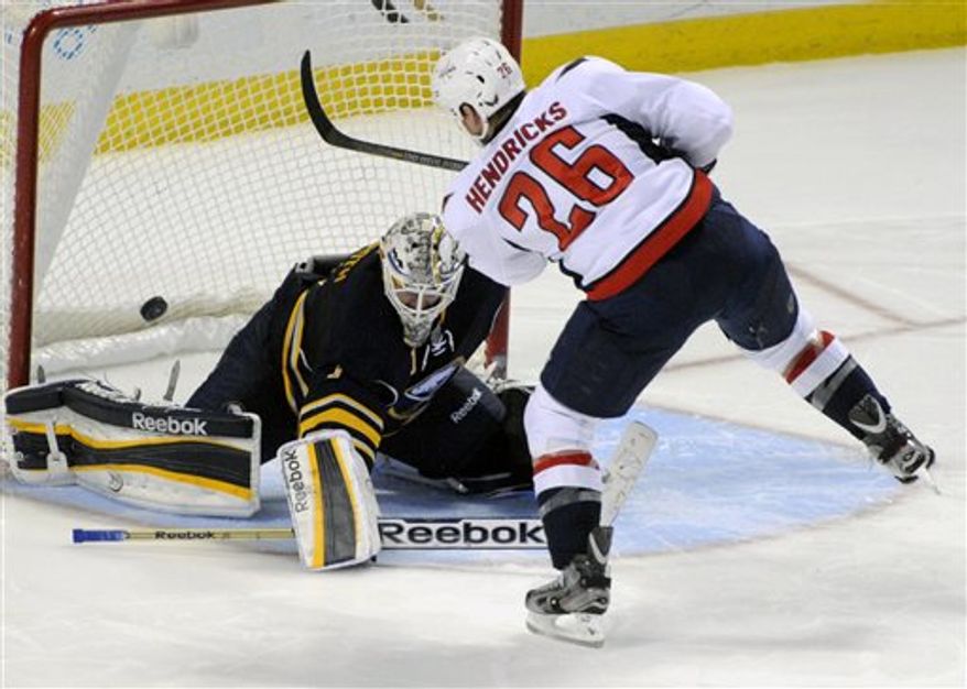 Buffalo Sabres' goaltender Jhonas Enroth (1), of Sweden, gets beat for goal by Washington Capitals' center Matt Hendricks (26) during the team shootout of an NHL hockey game in Buffalo, N.Y., Saturday, March 30, 2013. Washington won 4-3. (AP Photo/Gary Wiepert)
