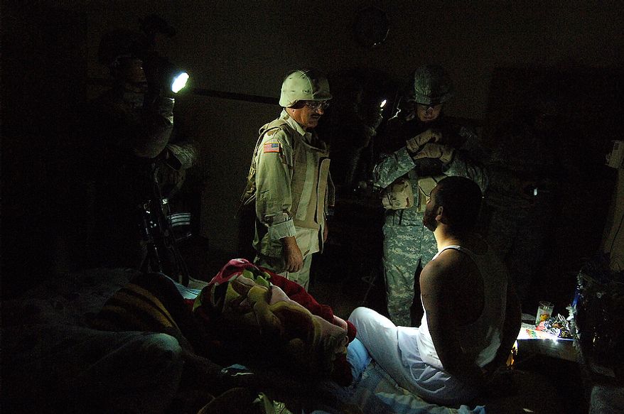 An Iraqi Army interpreter and a Soldier from Bravo Company 1/17th Infantry 172nd Stryker BDE Ft. Wainwright, AK question a suspect during an early morning cordon search of a house May 26, 2006 in the North West neighborhood of Al Nijar, Mosul, Iraq. Nine Iraqi's were detained in the searches, all suspected of terrorist activity as IED facilitators and enablers. (U.S. Air Force photo by TSgt Jeremy T. Lock)