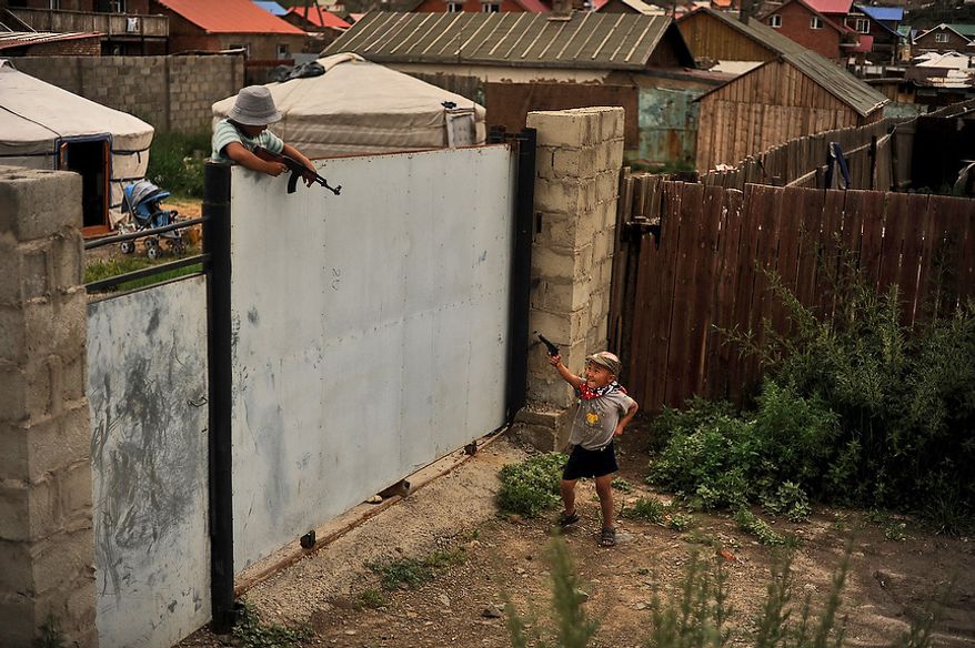 Two young boys run around and play with toy guns in the Ger District in Ulaanbaatar, Mongolia on July 28, 2012. Ger districts usually occupy poor quality land on the outskirts of town. (U.S. Air Force photo by Tech. Sgt. Jeremy T. Lock)