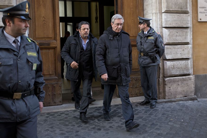 The Rev. Franco Decaminada (second from right) leaves an office of Italy's financial police after being questioned in Rome on Thursday, April 4, 2013. The Catholic priest, who is under house arrest, is accused of pocketing 4 million euros ($5.1 million) from the coffers of a Catholic hospital he ran and helping run up 600 million euros ($769 million) in debts that forced the clinic into bankruptcy and prompted the Vatican to intervene. (AP Photo/Andrew Medichini)