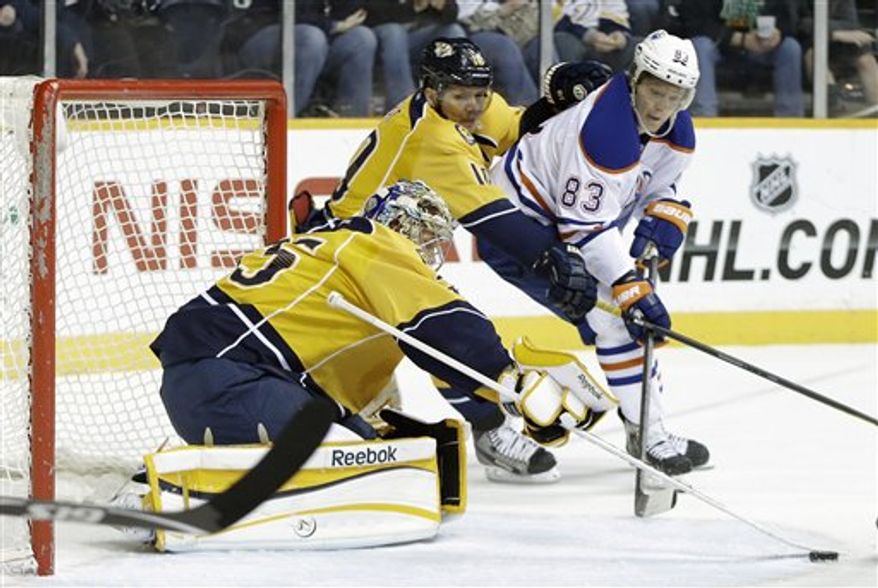 Nashville Predators goalie Pekka Rinne (35), of Finland, blocks a shot as left wing Martin Erat (10), of the Czech Republic, and Edmonton Oilers right wing Ales Hemsky (83), of the Czech Republic, chase after the rebound in the first period of an NHL hockey game on Monday, March 25, 2013, in Nashville, Tenn. (AP Photo/Mark Humphrey)