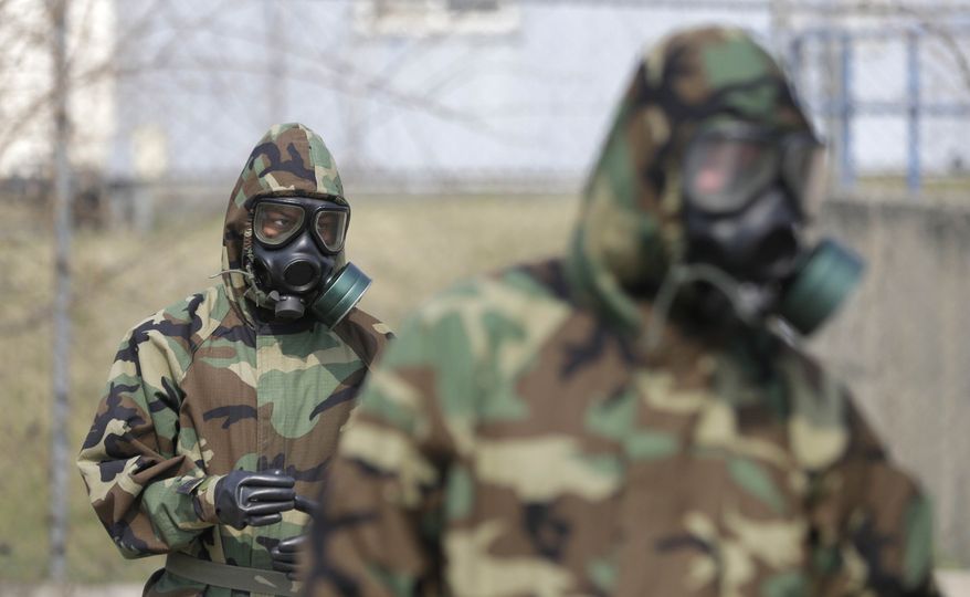 Soldiers of the U.S. Army 23rd chemical battalion wear gas masks while attending a demonstration of their equipment during a ceremony to recognize the battalion's official return to the 2nd Infantry Division based in South Korea at Camp Stanley in Uijeongbu, north of Seoul, Thursday, April 4, 2013. The 23rd chemical battalion left South Korea in 2004 and returned with some 350 soldiers in Jan. 2013. (AP Photo/Lee Jin-man)