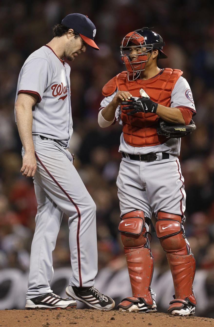 Washington Nationals' right-hander Dan Haren, left, chats with catcher Kurt Suzuki before he is pulled from his regular-season debut. Haren allowed four home runs in four innings and the Nationals gave up six home runs total in a 15-0 loss to the Cincinnati Reds. (Associated Press photo)