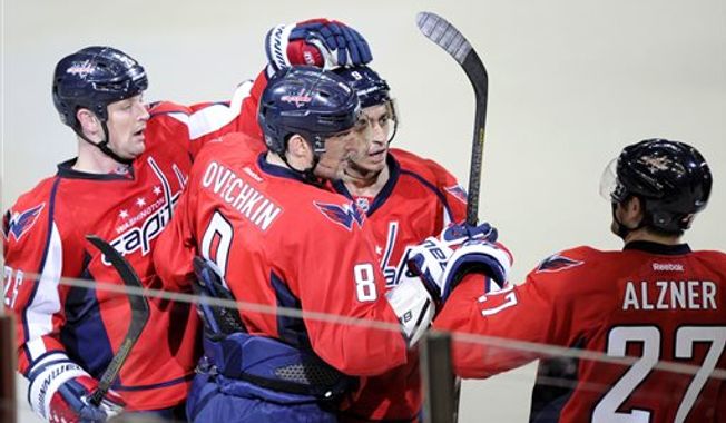 Washington Capitals left wing Alex Ovechkin (8), of Russia, celebrates his goal with teammates Matt Hendricks, left, Karl Alzner (27) and Mike Ribeiro (9) during the third period of an NHL hockey game against the Tampa Bay Lightning, Sunday, April 7, 2013, in Washington. The Capitals won 4-2. (AP Photo/Nick Wass)