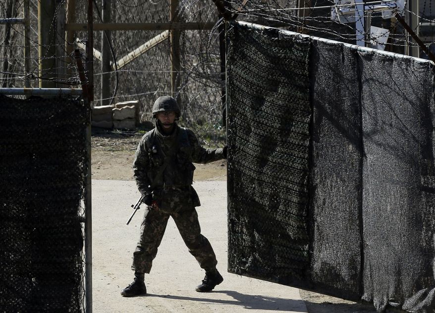 A South Korean soldier closes a military gate in Paju, north of Seoul, on Sunday, April 7, 2013. A top South Korean national security official said Sunday that North Korea may be setting the stage for a missile test or another provocative act with its warning that it soon will be unable to guarantee diplomats' safety in Pyongyang. But he added that the North's clearest objective is to extract concessions from Washington and Seoul. (AP Photo/Lee Jin-man)
