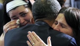 **FILE** President Obama hugs Newtown, Conn., family members after speaking at the University of Hartford in Hartford, Conn., on April 8, 2013. Obama said that lawmakers have an obligation to the children killed and other victims of gun violence to act on his proposals. (Associated Press)