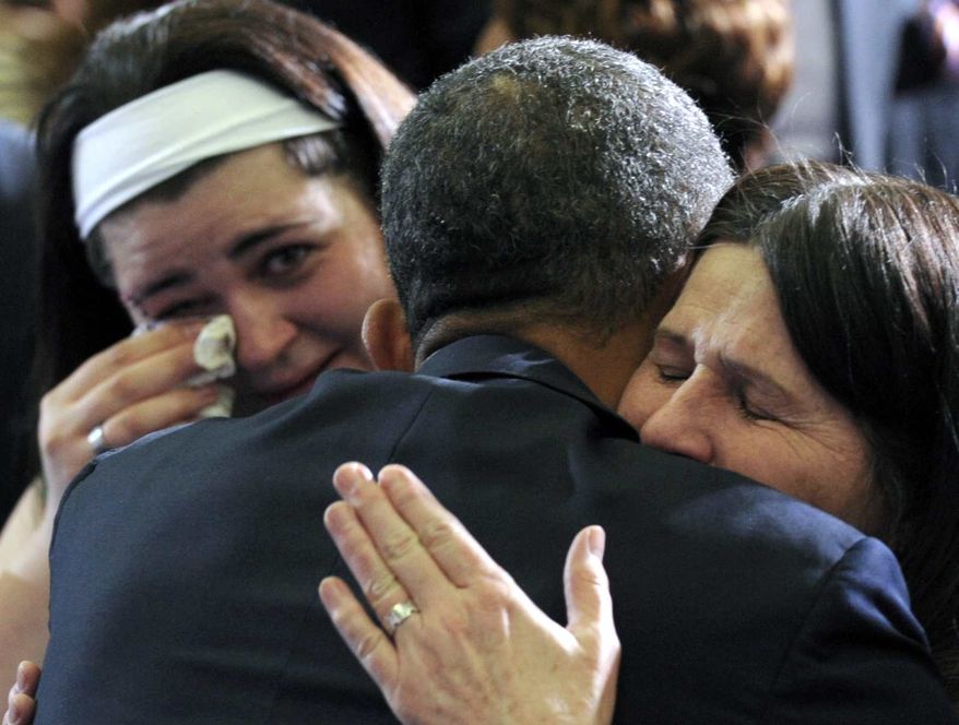 **FILE** President Obama hugs Newtown, Conn., family members after speaking at the University of Hartford in Hartford, Conn., on April 8, 2013. Obama said that lawmakers have an obligation to the children killed and other victims of gun violence to act on his proposals. (Associated Press)