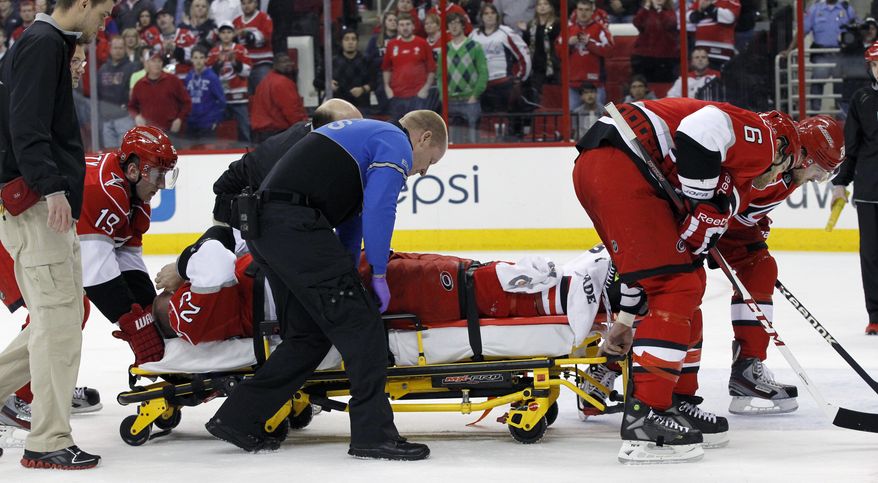 This April 2, 2013 photo shows Carolina Hurricanes hockey player Joni Pitkanen (25), of Finland, being taken off the ice on a stretcher with help from teammates Jiri Tlusty (19), far left, and and Tim Gleason (6), right, during the second period of an NHL game against the Washington Capitals in Raleigh, N.C. The Hurricanes say Pitkanen will miss the rest of the season with a broken heel. General manager Jim Rutherford disclosed the severity of Pitkanen's injury Wednesday, April 3, 2013. (AP Photo/The News & Observer, Chris Seward)