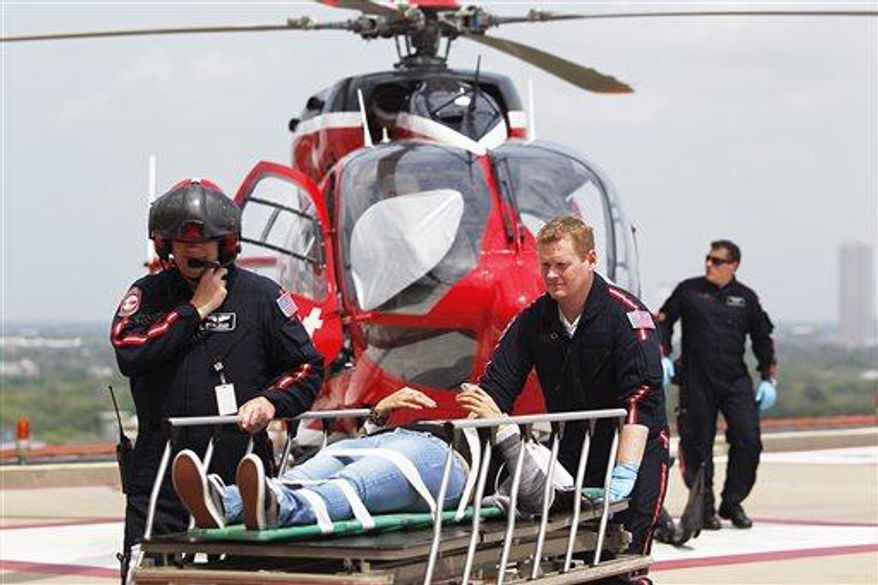 Life Flight personnel rush a victim wounded in a stabbing attack on the Lone Star community college system's Cypress, Texas campus into Memorial Hermann Hospital Tuesday, April 9, 2013, in Houston. The Harris County Sheriff's department confirmed at least 11 people wounded and that authorities have one suspect in custody. (AP Photo/Houston Chronicle, Johnny Hanson)