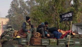 **FILE** In this citizen journalism image provided by Edlib News Network and authenticated based on its contents and other AP reporting, rebels from al Qaeda-affiliated Jabhat al-Nusra sit on a truck full of ammunition at Taftanaz air base, which was captured by the rebels, in the Idlib province of northern Syria. (Associated Press/Edlib News Network)