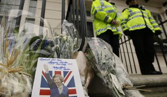 A card is left on a floral tribute outside former British Prime Minister the Baroness Thatcher&#39;s home in London on Tuesday, April 9, 2013. (AP Photo/Kirsty Wigglesworth)