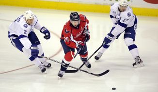 Washington Capitals right wing Troy Brouwer (20) battles for the puck against Tampa Bay Lightning defenseman Eric Brewer (2) and Tampa Bay Lightning center Alex Killorn (17) during the third period of an NHL hockey game, Sunday, April 7, 2013, in Washington. The Capitals won 4-2. (AP Photo/Nick Wass)