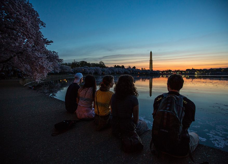 Students visiting the district, sit on the edge of the tidal basin as they watch the sunrise in Washington, DC., Thursday, April 11, 2013. (Andrew S Geraci/The Washington Times)
